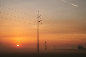 Fototapeta na wymiar Power line in fog in the early morning