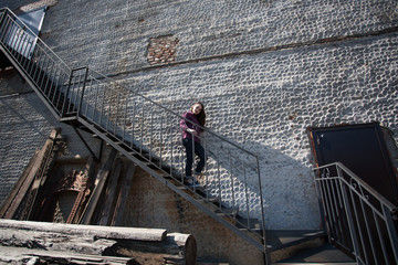 girl in plaid shirt posing against the wall