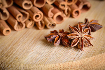  shelves of cinnamon and anise stars in dark backgrounds on a wooden background