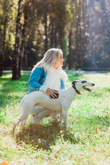beautiful adorable happy blonde woman owner with her whippet outdoor