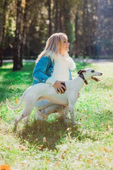beautiful adorable happy blonde woman owner with her whippet outdoor