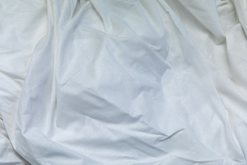 Top view of the crease of an unmade bed sheet in the bedroom after a long night sleep and waking up in the morning.