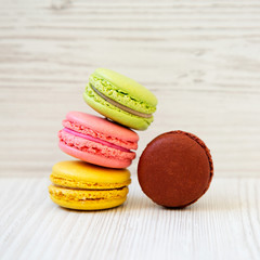 Sweet and colorful macaroons on a white wooden background, side view. Close-up.