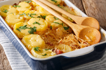 Bavarian baked food from sauerkraut with potatoes, bacon and cheese closeup on the table. horizontal