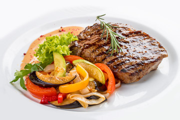 Pork steak with vegetable garnish. On a white plate