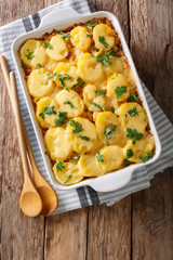 Bavarian sauerkraut casserole with potatoes, bacon and cheese close-up in a baking dish. vertical top view