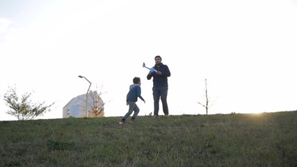 Happy family launching toy plane in park