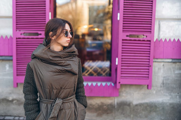 Pretty girl in coat sunglasses walking outdoor.
