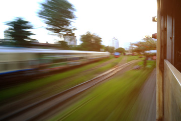 Low speed shutter or long exposure of upcountry view and the train with railway from the window of moving train