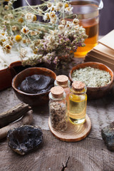Natural herbal skin care products, top view ingredients. Cosmetic oil, clay, sea salt, herbs, plant leaves. Facial treatment preparation background, skincare spa closeup