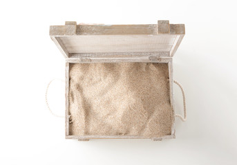 Opened wooden chest full with sand, on white background.