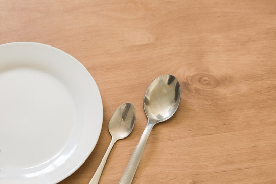 White plate with teaspoon and tablespoon background.