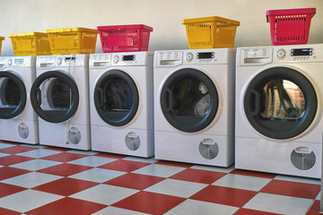 Washing machines in the Laundromat. Room with laundry machines. Sunny summer day. No people.