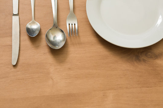 White plate with teaspoon and tablespoon background.