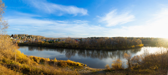 Beautiful panorama of morning on the calm river with village on their bank 