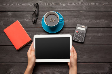  blank tablet device over a wooden workspace table with coffee top view