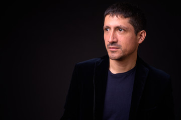 Fototapeta premium Portrait of Hispanic businessman against black background