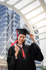 Young student woman smiling and  holding diploma certificate paper, graduation concept