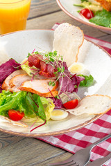 Fresh salad with chicken breast, arugula and tomato. Top view