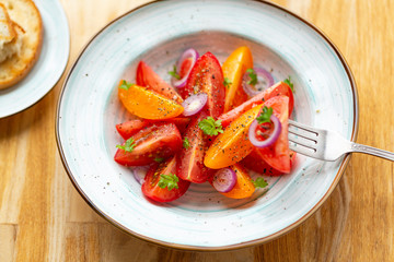 Traditional Italian salad with fresh tomatoes, onions and olive oil