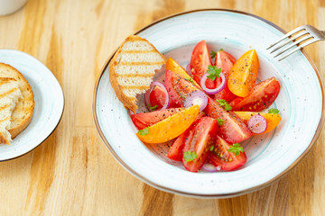 Traditional Italian salad with fresh tomatoes, onions and olive oil