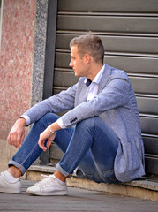 Urban stile young man sitting on floor