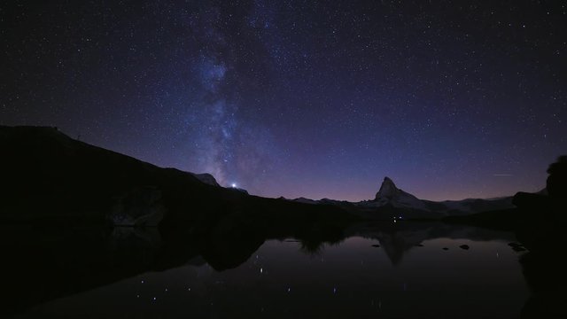 4K time lapse of Beautiful sky Color of the Matterhorn pyramid with milky way and all the star at Stellisee lake. Great reflection night scene in Swiss Alps, Zermatt, Switzerland, Europe