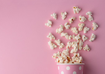 Spilled popcorn on a pink background, cinema, movies and entertainment concept
