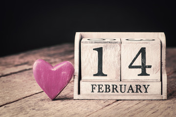Wooden calendar show of February 14. Pink heart.