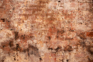 Faded brick wall. Orange bricks closeup. Weathered grungy brick wall photo background. Distressed texture of brickwork.