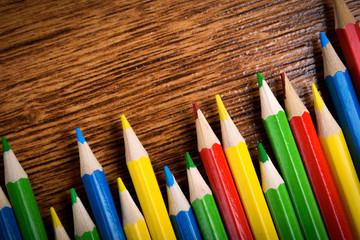 Different colored pencils on the brown wooden table background .Top view .Close up .Color .Pencil.Set