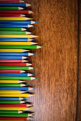 Different colored pencils on the brown wooden table background .Top view .Close up .Color .Pencil.Set