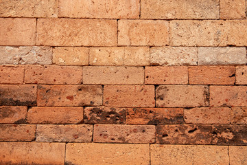 Fresh brick wall. Orange bricks closeup. Weathered grungy brick wall photo background. Distressed texture of brickwork