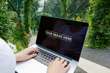Laptop laying on woman knees in park mockup