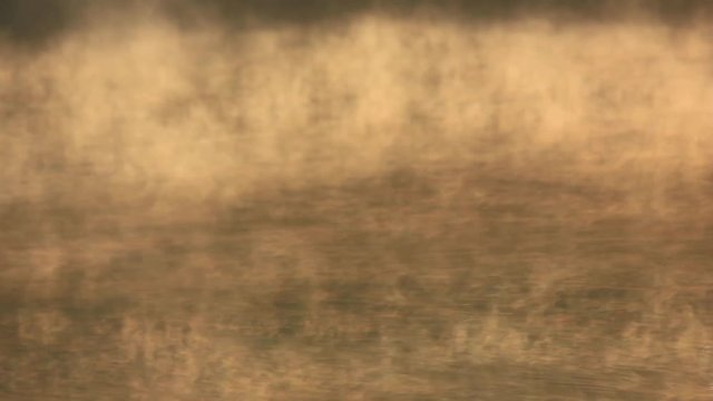 Fog flowing over water surface of the lake 