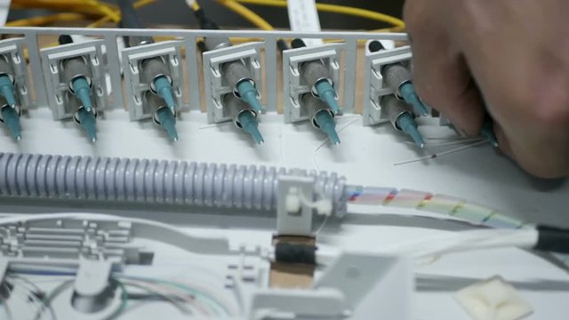 Technicians are installing optic fiber with cable ties.