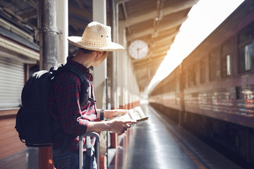 Man Traveler holding map and backpack while waiting for the train,Travel concept.copy space.