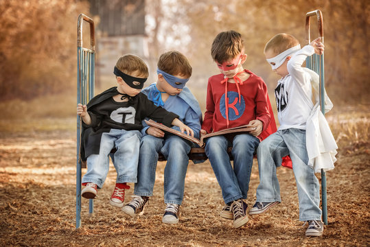 Four boys dressed as superheroes show off the power of each other