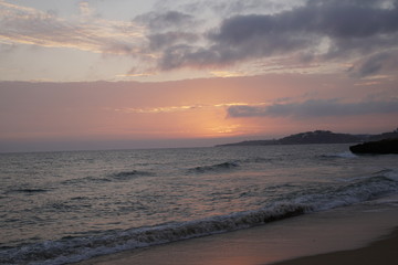 Ocean in the evening. Sunset over the waves. Clouds and bright colors of the evening sky. Orange red azure