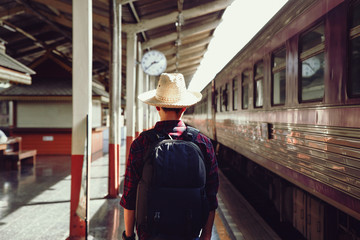 Young traveler man stand on railroad station,Travel concept.copy space.