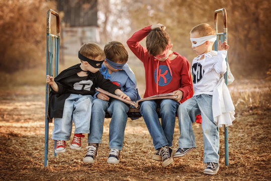 Four boys dressed as superheroes show off the power of each other