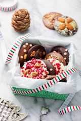 Chocolate mediants, bites, candies in a gift box for Christmas and New Year celebration. Marble background.