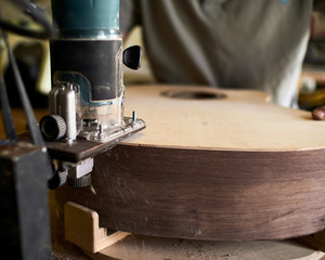 Luthier Install Binding on an guitar. Chamfering on the body of the guitar.