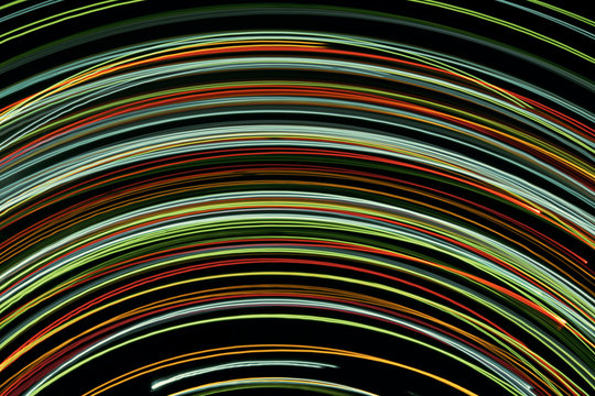 Blurred bright luminous multicolored stripes in the form of an arc from diode bulbs LED from Christmas lights screen closeup. Bright abstract background ideal for any design
