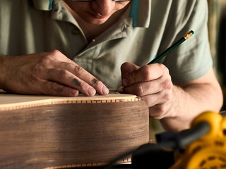 Luthier Install Binding on an guitar. Chamfering on the body of the guitar.