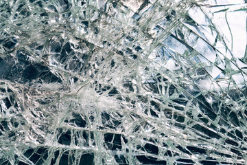 Criminal incident at the bus stop. Shooting a pistol. Hole and cracks in the glass of a city bus stop. Cracked glass texture against the blue sky. Cracked glass with a hole from a bullet. Vandalism