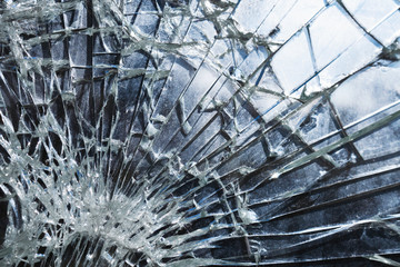 Criminal incident at the bus stop. Shooting a pistol. Hole and cracks in the glass of a city bus stop. Cracked glass texture against the blue sky. Cracked glass with a hole from a bullet. Vandalism