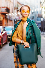 Outdoor fashion portrait of young fashionable girl wearing autumn outfit: orange glasses,...
