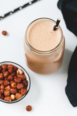 Nut butter chocolate protein shake in a glass jar. The concept of a healthy lifestyle and fitness diet.