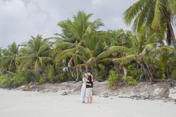 Young couple in love kissing on exotic destination on tropical beach. Couple in love travel on honeymoon on exotic island. Honeymoon beautiful couple on exotic palm beach